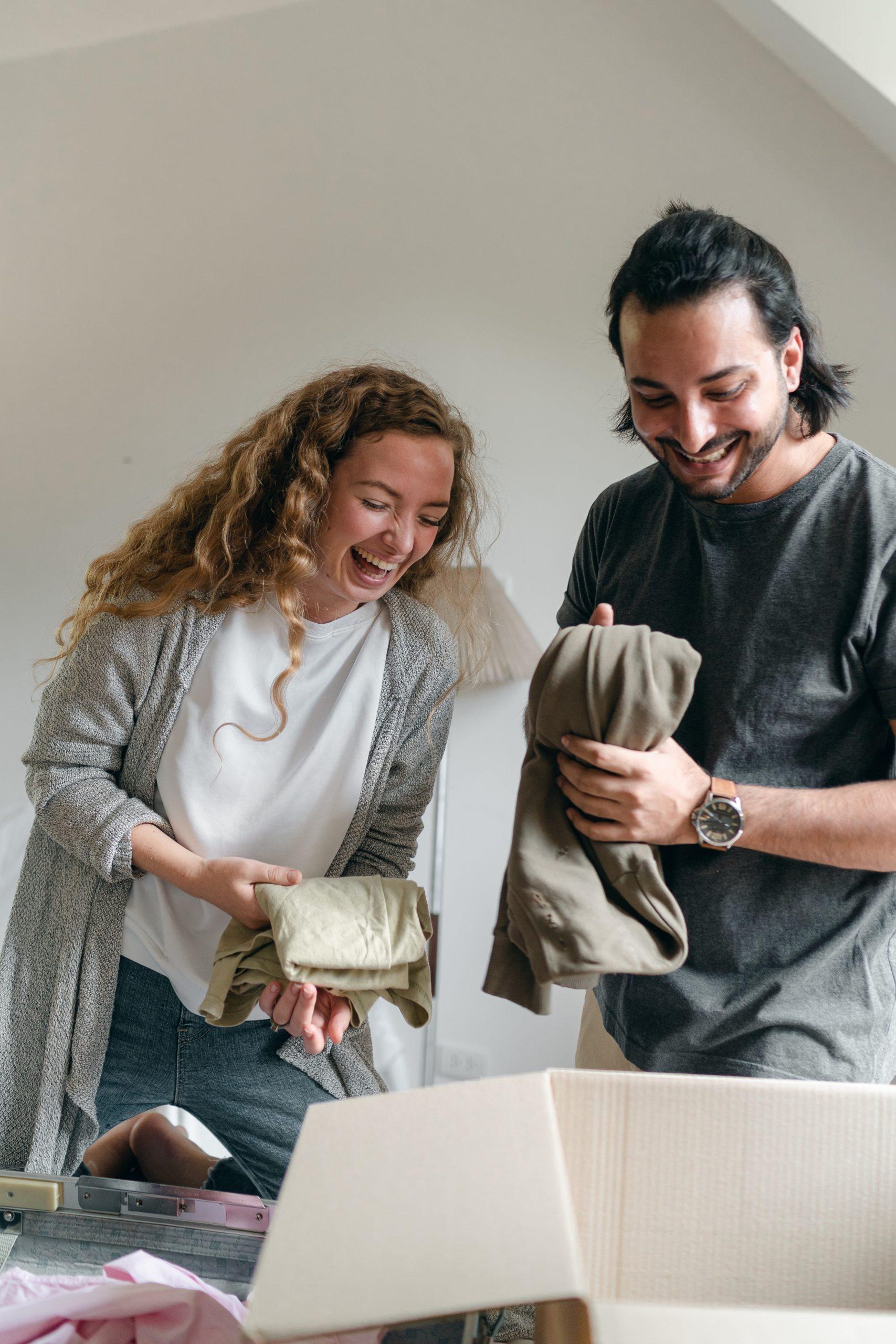 Couple laughing while packing boxes